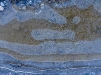 Längliche und runde Struktur in klarer Eisschicht